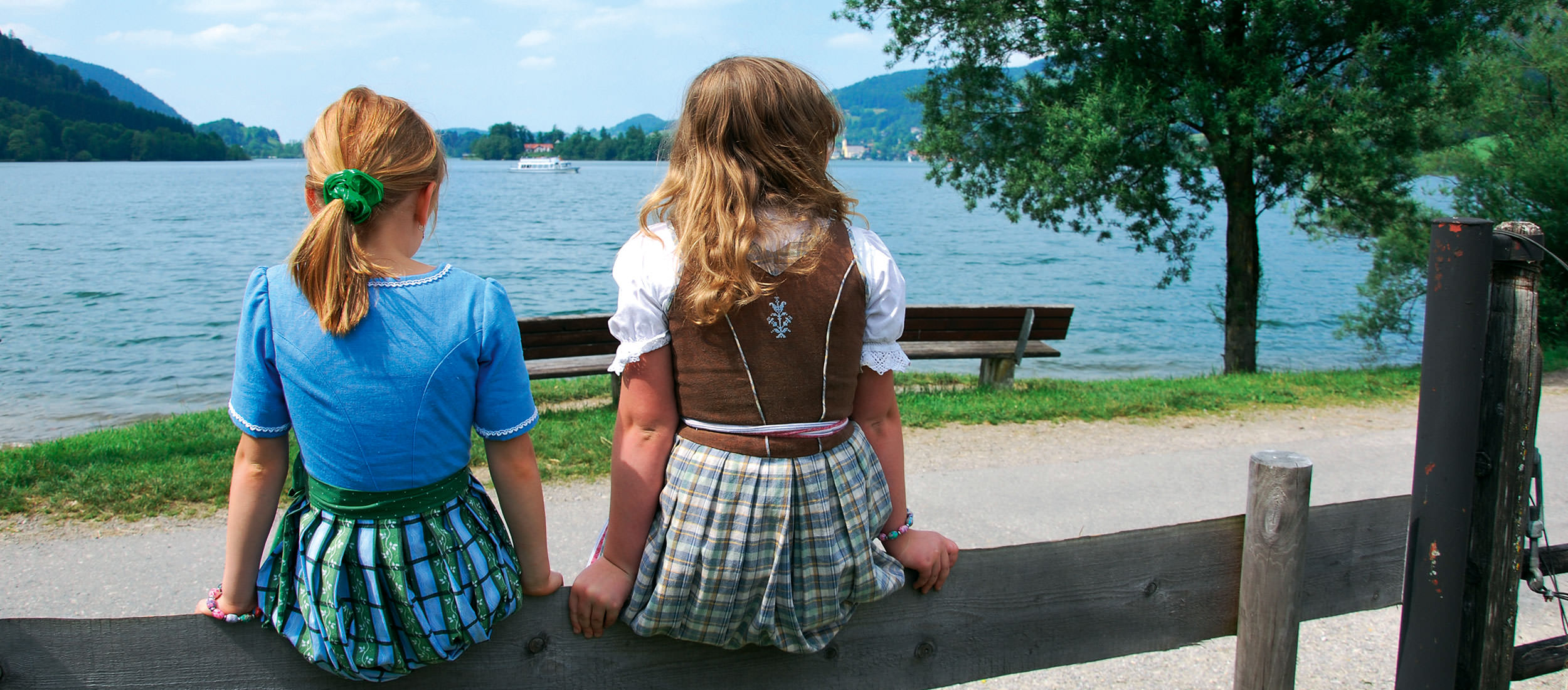 Zwei kleine Mädchen in Tracht blicken auf den Schliersee